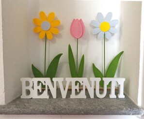 A welcome sign with three felt flowers and the word 'BENVENUTI' on a granite countertop. - Apartment 'Casa Matilde' with Private Garden, Wi-Fi and Air Conditioning (Moncalieri)