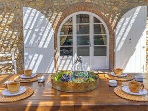 A table set with a glass vase, a bowl of fruit, and several cups and saucers. - Il Sogno Toscano by Interhome (Casale Marittimo)