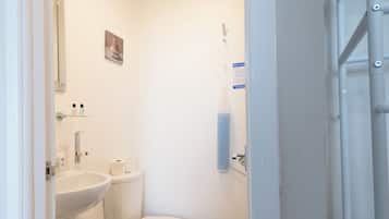 A small, clean bathroom with a toilet, sink, and a towel rack.