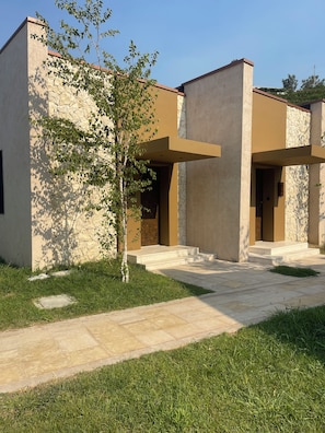 A modern building with a stone facade, a flat roof, and a paved entrance area. - La Reserve by Duka Winery (Ishem)