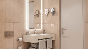 A modern bathroom with a toilet, sink, and large mirror. - La Reserve by Duka Winery (Ishem)