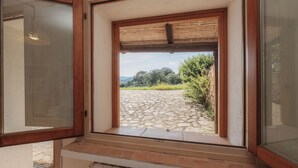 Una habitación con vistas, un camino de piedra y follaje verde en el exterior.