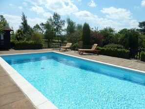 A rectangular swimming pool with clear blue water, surrounded by a tiled deck. - Six Apples (Braintree)