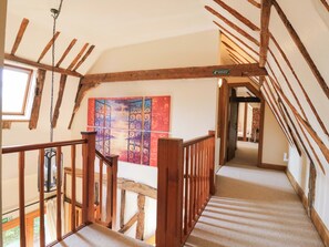 A wooden staircase with a view of a room featuring a colorful artwork. - Six Apples (Braintree)