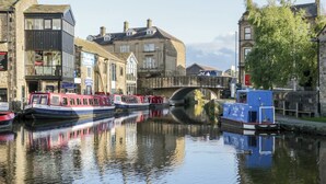 A canal with boats, a bridge, and buildings along the water. - Number 7 Canalside (Skipton)