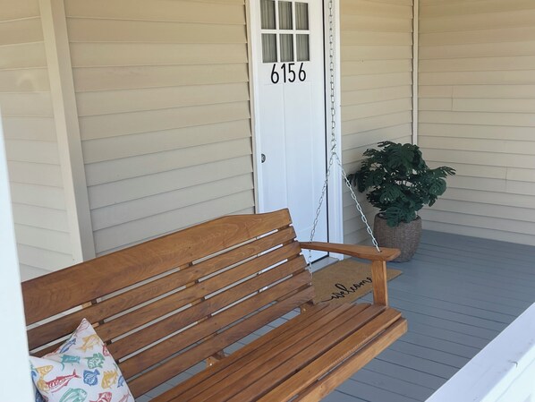 A wooden bench on a porch with a door marked '6156' and a potted plant. - Fishing, Crabbing, Relaxing..... You will enjoy whichever you decide to do. (Chauvin)