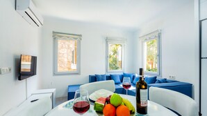 A dining area with a table set for two, a bottle of wine, and fruit. - 2 bedroom Townhouse Located Heart of Kalkan Old Town (Kalkan)