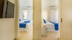 Een hotelkamer met twee bedden, een televisie en een airconditioner.