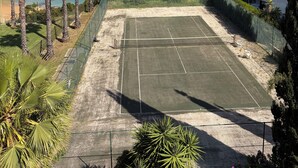 A tennis court with a view of the ocean and palm trees. - Renovated 2BR Lagos w/ Pool & Garage by Soulplaces (Lagos)