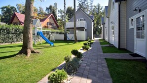 Zona residencial con un parque infantil, un sendero y casas.