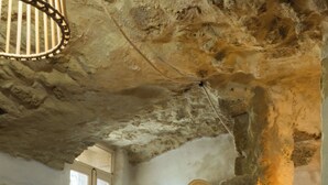 A rustic stone interior with a window, a hat on the wall, and a lamp. - L'Orée du Castel - Gîte at the foot of the castle (Châteauneuf-du-Pape)