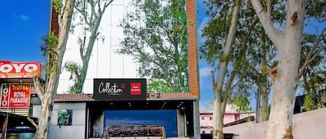 A hotel entrance with a modern facade, a staircase leading up, and a sign for the Royal Paradise Hotel.