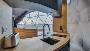 A modern kitchen with a large window, a built-in sink, and a toaster. - Bel Air Tremblant DÔME CLASSIQUE: 1 LIT KING, JACUZZI ET SAUNA-450PI (La Conception)