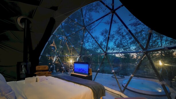 A tent with a bed, a laptop, and a hot tub. - Bel Air Tremblant DÔME CLASSIQUE: 1 LIT KING, JACUZZI ET SAUNA-450PI (La Conception)