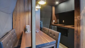 A compact kitchen with a wooden table and bench, a refrigerator, and a sink. - Bel Air Tremblant DÔME MEZZANINE : 1 KING, 2 SIMPLE, JACUZZI, SAUNA-450PI (La Conception)