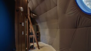 A room with a high ceiling, a wooden ladder, and a window. - Bel Air Tremblant DÔME MEZZANINE : 1 KING, 2 SIMPLE, JACUZZI, SAUNA-450PI (La Conception)
