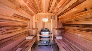 A sauna with wooden walls, benches, and a control panel. - Bel Air Tremblant DÔME DELUXE : 1 LIT KING, JACUZZI, SAUNA-700PI (La Conception)