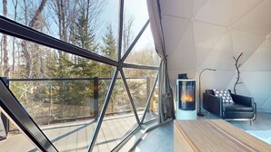 Ein modernes Interieur mit großen Fenstern, einem Kamin und einer hölzernen Bank.