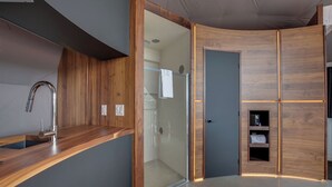 A modern kitchen with a wooden countertop, a stainless steel faucet, and a built-in oven.