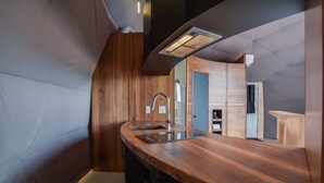 A modern kitchen with a wooden countertop, stainless steel sink, and a built-in oven.