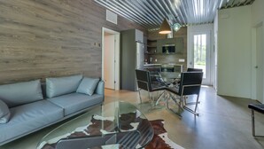 A modern living room with a glass coffee table, leather sofa, and a cowhide rug. - Bel Air Tremblant ANDORRA: 2 CHAMBRES, JACUZZI (La Conception)