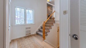 A staircase with wooden railings and a stone wall, leading to an upper floor. - Stratton; walk on/off, shuttle Rt, pool table, shuffle puck, darts, dogs OK (Winhall)