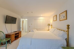 A bedroom with a bed, a television, a desk, and a chair. - Stratton walk on/ski off, King bed, walk 2 food/drink (Stratton)