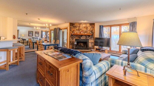 A cozy living room with a fireplace, wooden furniture, and a television. - Stratton walk on/off, walk to food/drink, fireplace (Stratton)