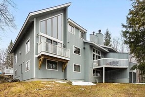A modern two-story house with a balcony, a garage, and a large yard. - POOL! Ski/walk on/off, King beds, Hot Tub (Stratton)