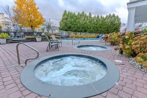 Un espace spa comprenant deux bains à remous, des chaises longues et une piscine.