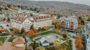 A large hotel with multiple buildings, a central courtyard, and a mountainous backdrop.