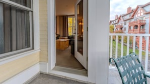 A residential entryway with a sliding glass door leading to a living room with a sofa and coffee table.