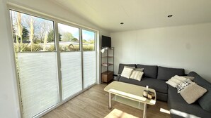 Ein modernes Wohnzimmer mit einer Couch, einem Couchtisch und einem Fernseher.