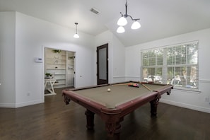 A pool table in a room with white walls, a window with blinds, and a door leading to a storage area. - BULVERDE VACATION HOME (San Antonio)