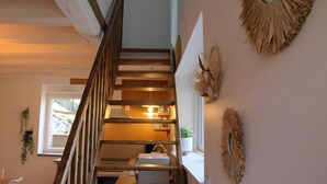 Eine Treppe mit hölzernen Geländern und einer weißen Kiste am Fuß.