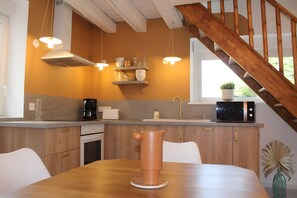 A kitchen with wooden cabinets, a coffee maker, a microwave, and a hanging light fixture. - Chez Cocotte 4–6 Guests with Heated Pool from Mid-May to September (Veuzain-sur-Loire)