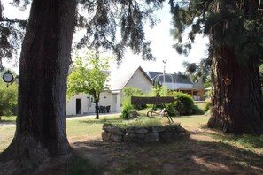 A rustic building with a stone wall, a wooden sign, and a large tree in the foreground. - Chez Cocotte 4–6 Guests with Heated Pool from Mid-May to September (Veuzain-sur-Loire)