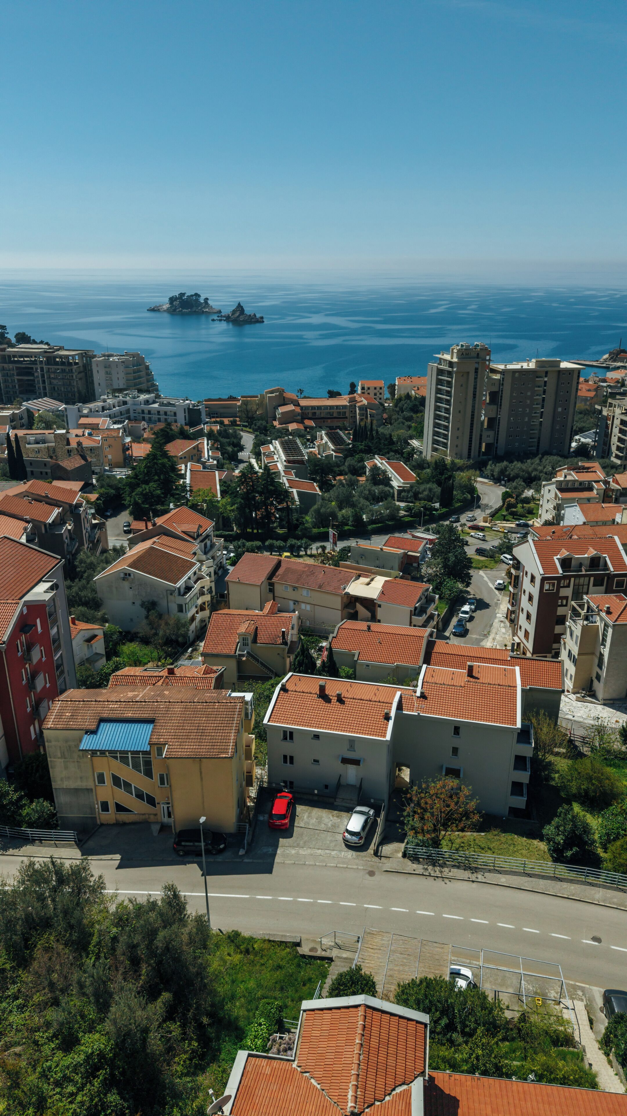 Una zona residenziale costiera con edifici, una strada e vista sul mare.