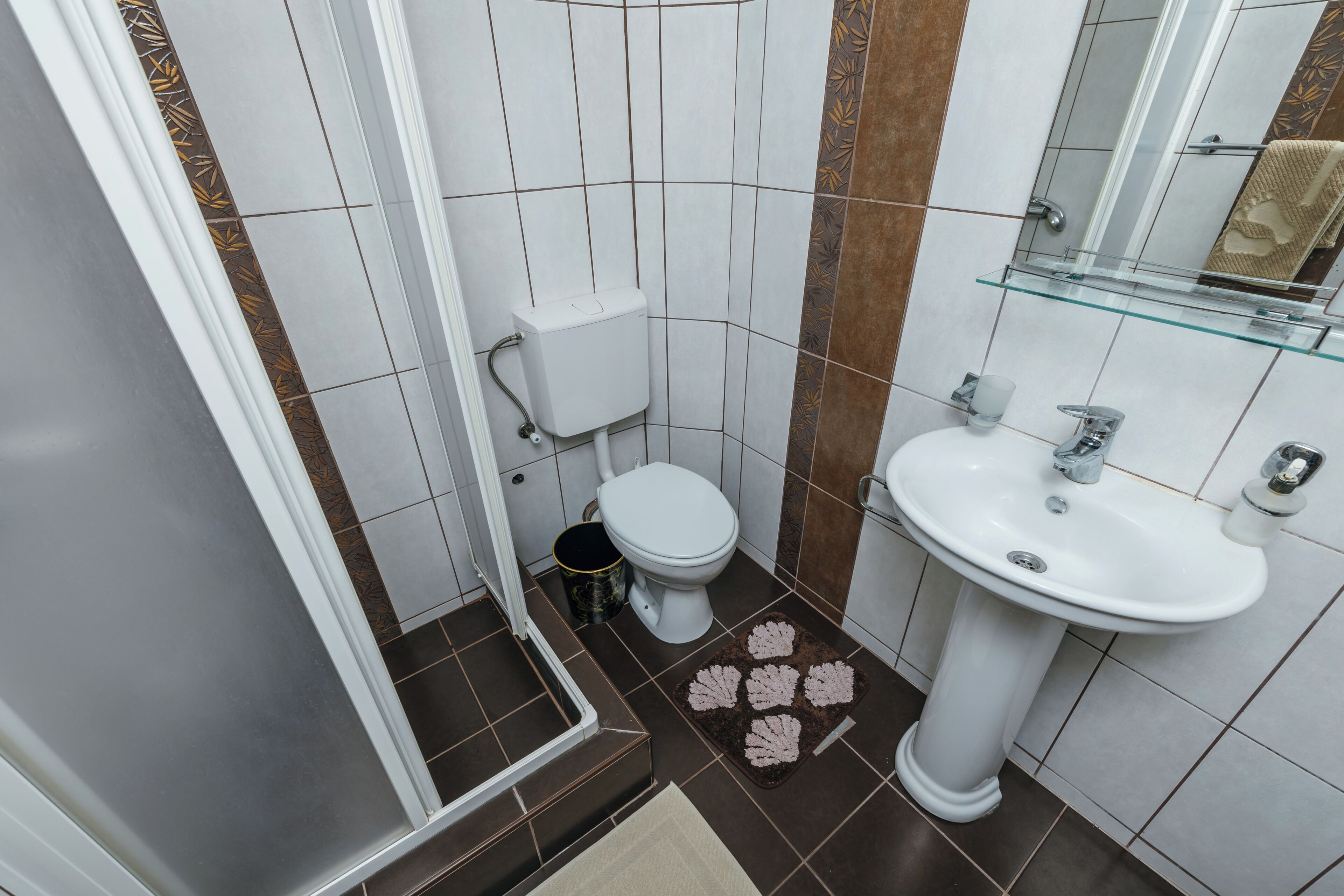 A bathroom with a toilet, sink, and shower.