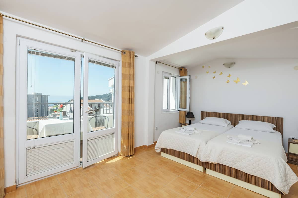 Un dormitorio con una cama grande, una ventana con vistas y un balcón.