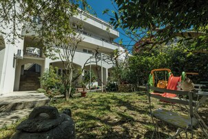 A courtyard with a play area, a stone sculpture, and a building with multiple balconies.