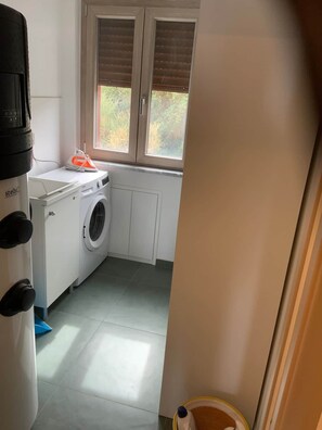 A laundry area with a washing machine, a dryer, and a water heater. - Alexandr Aurora House (Pizzo)