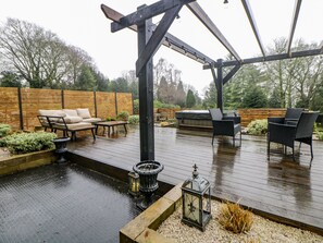 An outdoor deck with a hot tub, seating area, and a pergola structure. - Hallfield Hall Cottage (Alfreton)