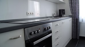 Eine Küche mit Herd, Backofen und Wasserspender.