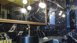 A modern bathroom with a black marble sink, a large mirror, and a washing machine. - Premium Designer Retreat in Central Athens Gizi (Athina)