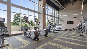 Ein Fitnessstudio mit Laufbändern, Crosstrainern und Gewichten.
