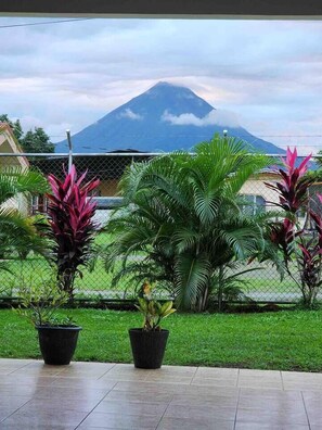 A view of a mountain with a fence in the foreground and potted plants. - Gray Oasis, Private Pool (La Fortuna)