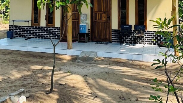 A two-story building with a tiled porch, wooden doors, and a small garden area. - Bintang Sawarna 2 By ARBA (Bayah)