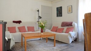 A living room with two white sofas, a wooden coffee table, a floor lamp, and a vase with flowers. - Farmhouse Gîte - "La Popote" (Passenans)