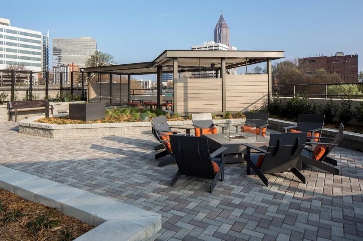 An outdoor patio with seating, a covered area, and a cityscape view.